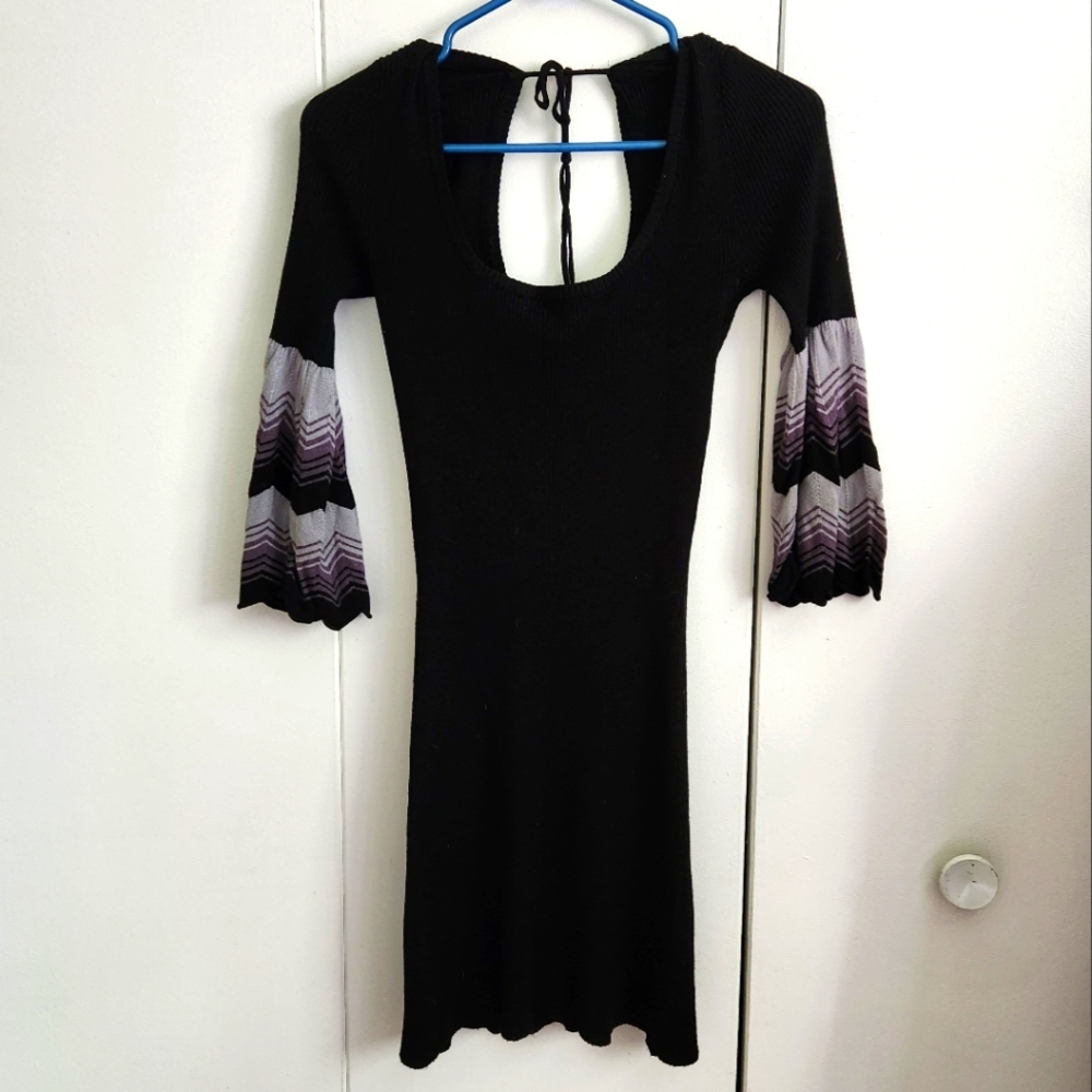 Black ribbed knit dress with tie in the back and bell sleeves. Scoop neck.